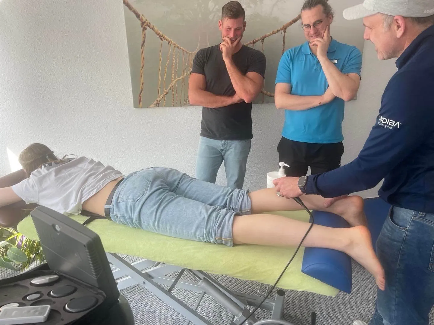 Drei Therapeuten besprechen eine Behandlung gemeinsam am Patienten