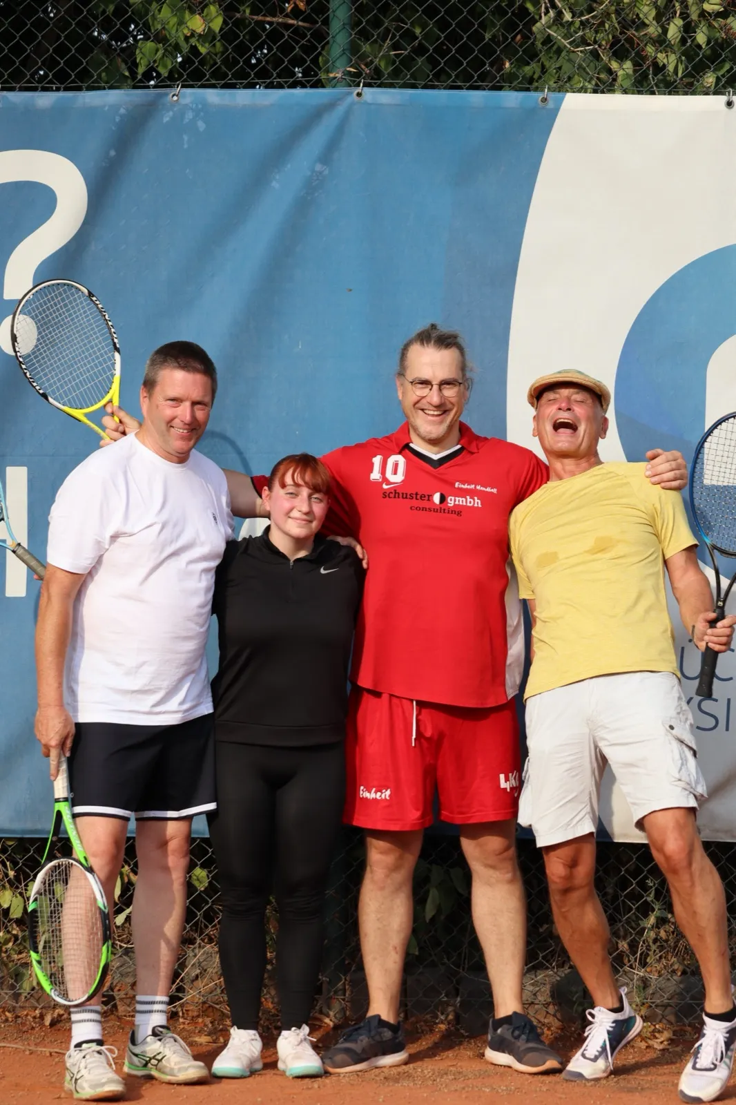 Vier Mitglieder des FPZ-Teams mit Tennisschlägern auf dem Platz